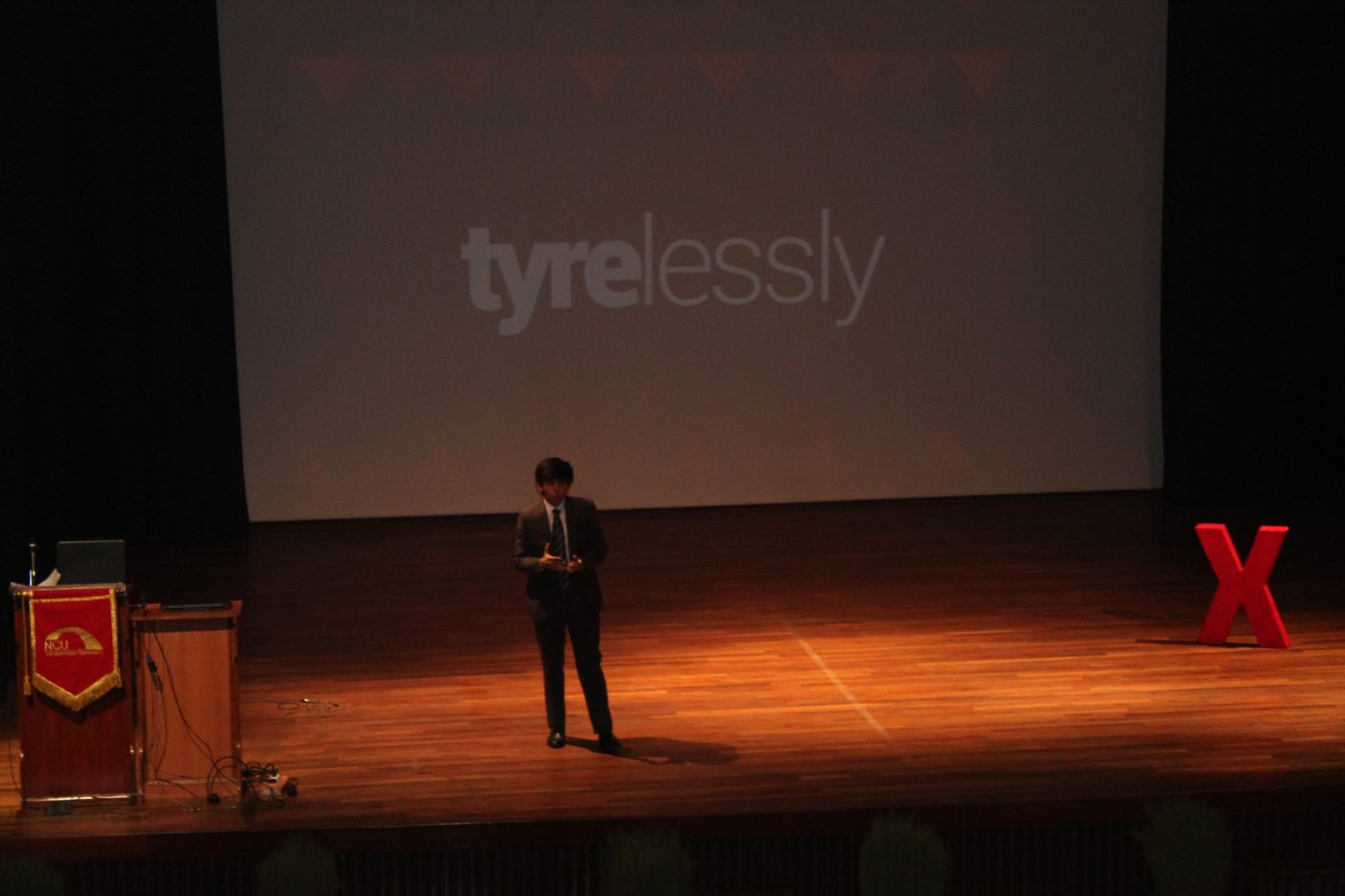 Anubhav Wadhwa speaking at TEDxTheNorthCapUniversity, with the Tyrelessly logo on screen